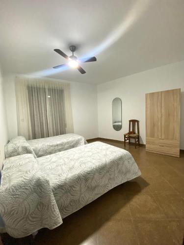 a bedroom with two beds and a ceiling fan at Casa Cruz de Marbella Luque in Luque