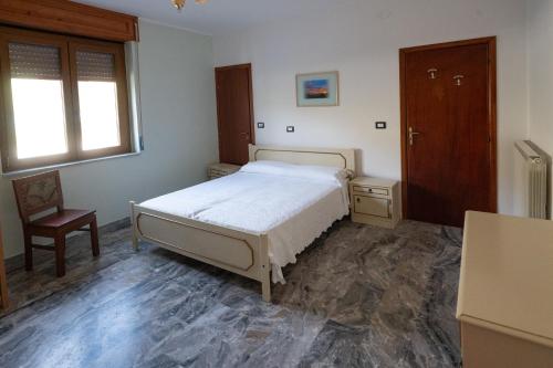 1 dormitorio con 1 cama, 1 silla y 1 ventana en La Vecchia Cascina, en Atena Lucana