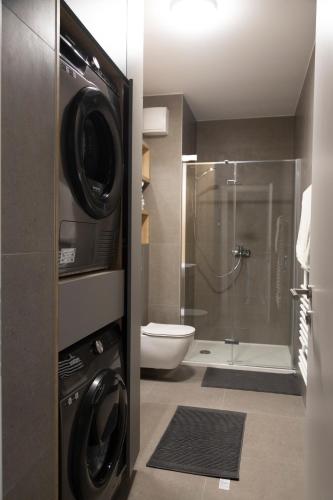 a bathroom with a toilet and a shower with a washer at The Dome in Zagreb