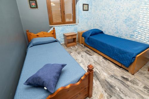 1 dormitorio con 2 camas y mesita de noche en La Vecchia Cascina, en Atena Lucana