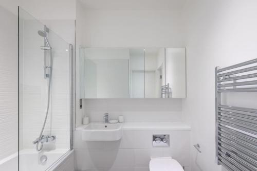 a white bathroom with a sink and a mirror at Central 2BR Urban Haven Rooftop Terrace in Bracknell