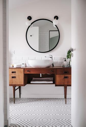 une salle de bain avec un lavabo et un miroir dans l'établissement 64 Sur Le Mail, à La Rochelle