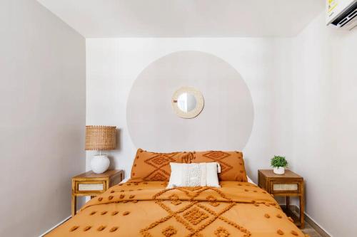 a bedroom with a bed with an orange bedspread at Apart tranquilo y comodo al lado de playa y mall plaza in Barranquilla