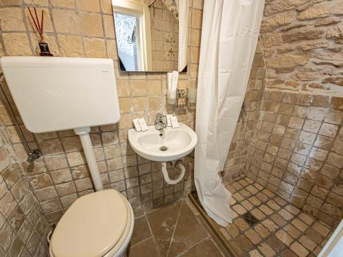 La salle de bains est pourvue de toilettes et d'un lavabo. dans l'établissement Martine Dimore Storiche di Puglia, à Martina Franca