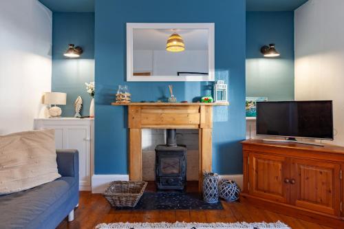 a living room with a fireplace and a tv at Family Home with Bunk Beds, Courtyard, TV & Beach in Pembrokeshire