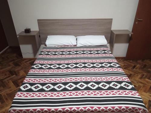 Un dormitorio con una cama con una manta de colores. en Nilo en San Rafael