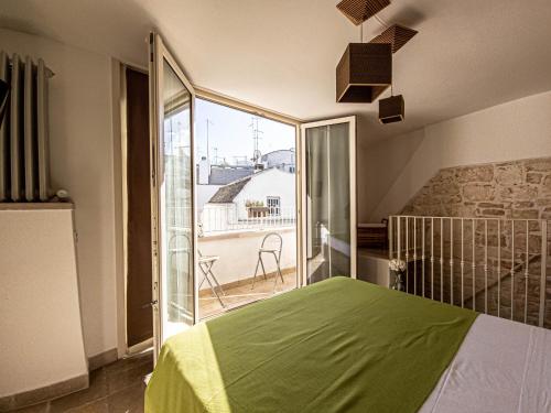 a bedroom with a green bed and a balcony at Martine Dimore Storiche di Puglia in Martina Franca