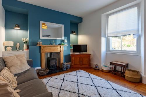 a living room with a couch and a fireplace at Family Home with Bunk Beds, Courtyard, TV & Beach in Pembrokeshire