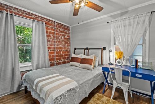 a bedroom with a brick wall and a bed and a desk at Down By The Bay w Hot Tub, 2 Blocks 2 Beaches, Game Room, Reading Nook, Dog-Friendly, Historic Charm in Panama City