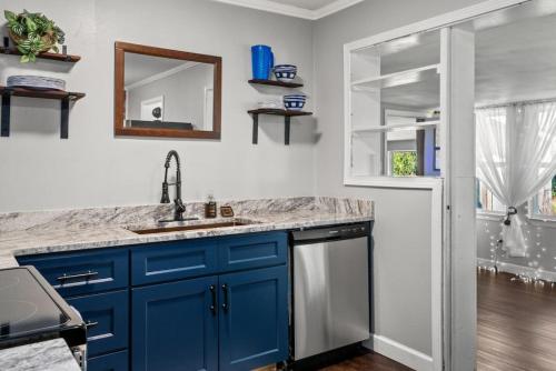 a kitchen with blue cabinets and a sink at Down By The Bay w Hot Tub, 2 Blocks 2 Beaches, Game Room, Reading Nook, Dog-Friendly, Historic Charm in Panama City