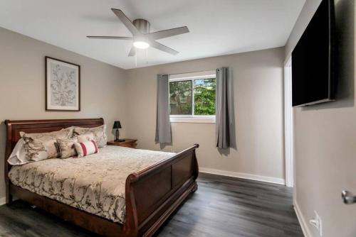a bedroom with a bed and a ceiling fan at Cozy Cumberland ATL Home w Hot Tub in Atlanta