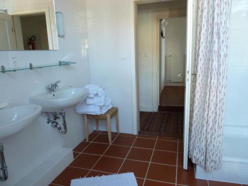 a bathroom with two sinks and a mirror and a shower at Hof Homfeld in Ditzum