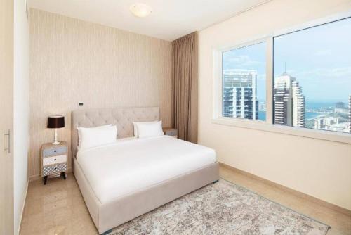 a bedroom with a white bed and a large window at Marina One Bedroom - KV Hotels in Dubai