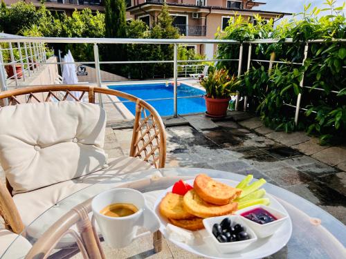 a plate of food on a table next to a pool at ArdoVel Park Hotel in Velingrad