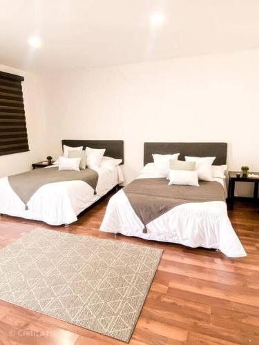 two beds in a room with wooden floors at Departamento Plata Cielito in Jesús María