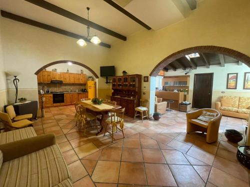 サンタ・テレーザ・ディ・リーヴァにあるCasa Vacanze Riva Bluの広いリビングルーム(テーブル付)、キッチンが備わります。