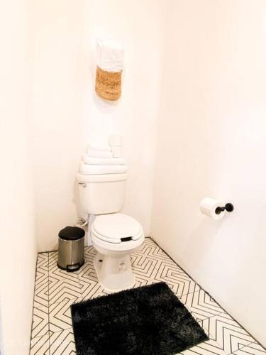 a bathroom with a toilet and a black rug at Departamento Plata Cielito in Jesús María