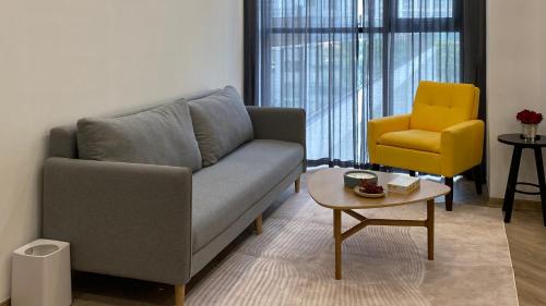 a living room with a couch and a yellow chair at JB Minato Garden in Hai Phong