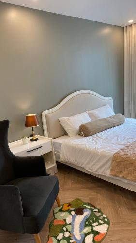 a bedroom with a bed and a chair and a table at JB Minato Garden in Hai Phong