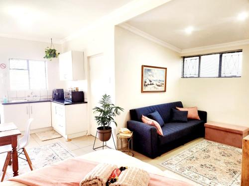 a living room with a couch and a kitchen at Bayside Bliss Studio Apartment in Summerstrand