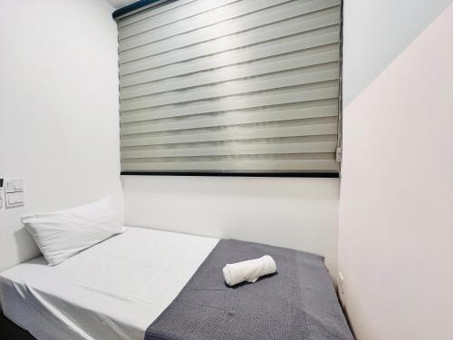 a small bedroom with a bed with a towel on it at Urban Suite Cozy Family Homestay at Georgetown by URBAN STAYCATION HENG LOD in Jelutong