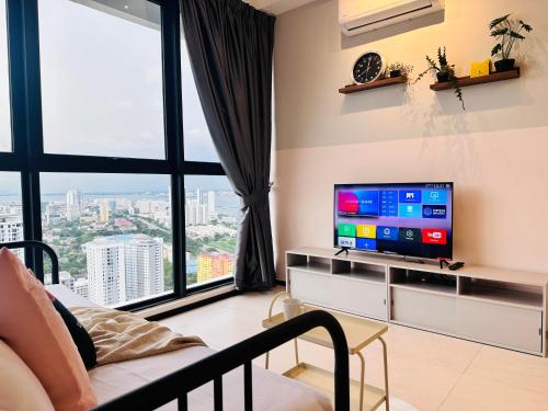 a living room with a tv and a large window at Urban Suite Cozy Family Homestay at Georgetown by URBAN STAYCATION HENG LOD in Jelutong