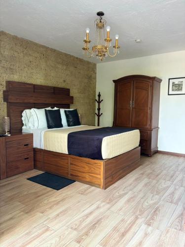 a bedroom with a large bed and a chandelier at Hotel Boutique La Mansión Guadalajara in Guadalajara