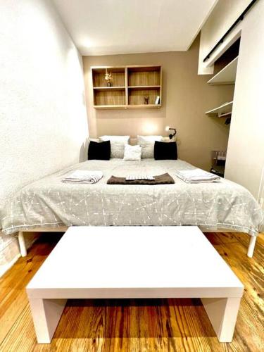 - une chambre avec un lit blanc et un banc blanc dans l'établissement Studio quartier prisé des Carmes, à Toulouse