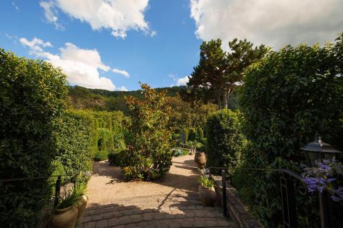a garden with bushes and trees and a fence at Wein und Landhaus Kallfels in Kröv