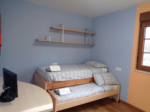 - une petite chambre avec un lit et un bureau dans l'établissement La Cuquina, à Villaturiel
