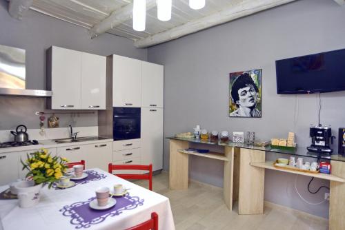 a kitchen with white cabinets and a white table with a table sidx sidx at B&B Parva Domus in Lamezia Terme