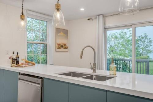 a kitchen with a sink and two windows at Lakeside Bliss Breathtaking View in Port Hope