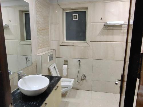 a white bathroom with a sink and a toilet at Taj Inn Residency in New Delhi