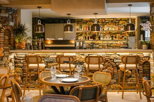 a restaurant with a table and chairs and a bar at Paramithenio Village Beach Resort & Spa in Áyioi Apóstoloi