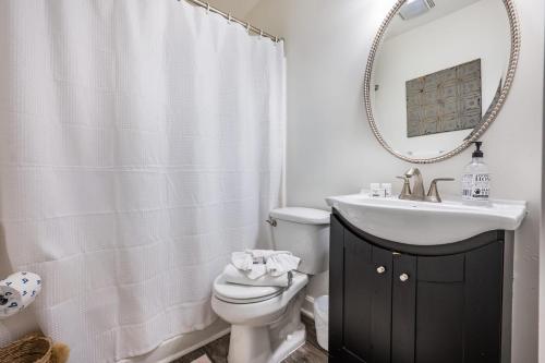 un bagno con lavandino, water e specchio di The Folly Feeling 1 Block to Beach a Folly Beach