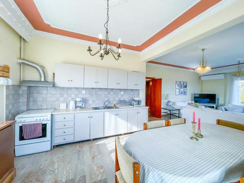 a kitchen with a table and a kitchen with white cabinets at Country Home Genesi 20 min from Trikala in Genésion