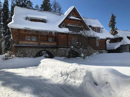 a pile of snow in front of a log cabin at PŁAZÓWKA POD LASEM in Murzasichle