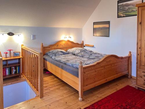 a bedroom with a wooden bed and a book shelf at Harz im Glück - Fachwerkhaus für zwei in Wernigerode in Wernigerode