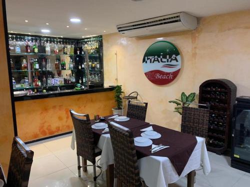 a restaurant with a table and chairs and a bar at hotel italia beach fortaleza in Fortaleza