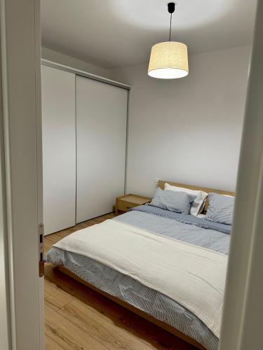 1 dormitorio con 1 cama y luz colgante en City Centre Apartment en Patras