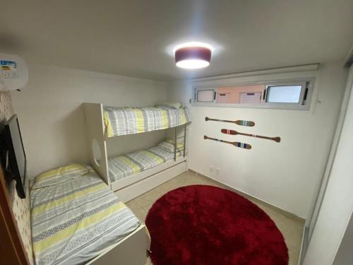 Habitación pequeña con 2 literas y alfombra roja. en Porto Brasil Resort, en Parnamirim
