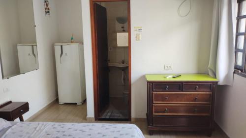 sypialnia z komodą, umywalką i lustrem w obiekcie Pousada Costa da Praia w mieście Praia Grande