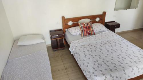 małą sypialnię z łóżkiem i szafką nocną w obiekcie Pousada Costa da Praia w mieście Praia Grande