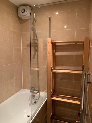 a shower with a glass door in a bathroom at Cosy spacious master room. in London