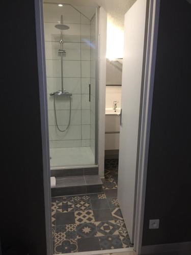 une salle de bain avec une douche avec une porte vitrée dans l'établissement Studio, étage 3, spacieux refait à neuf, à Belfort