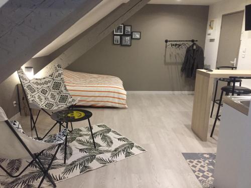 Cette chambre mansardée comprend un lit et une chaise. dans l'établissement Studio, étage 3, spacieux refait à neuf, à Belfort