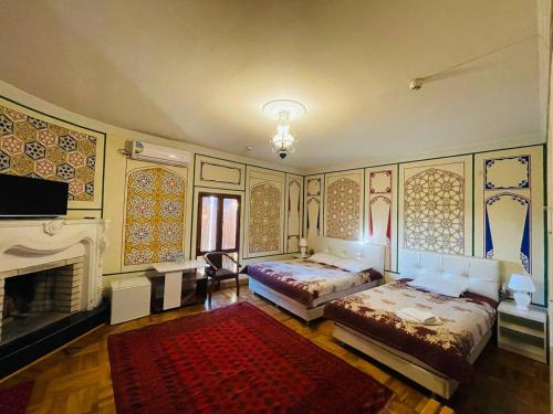 a large room with two beds and a fireplace at "CHOR MINOR" BOUTIQUE HOTEL Bukhara Old Town UNESCO HERITAGE List Est-Since 2003 Official Partner of Milano La Rosse Aroma in Bukhara
