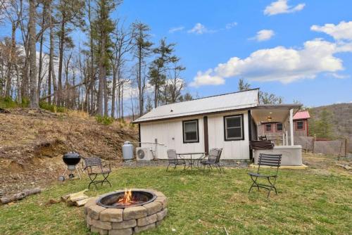 a house with chairs and a fire pit in the yard at Clementine Cottage at Doe Creek in Blowing Rock