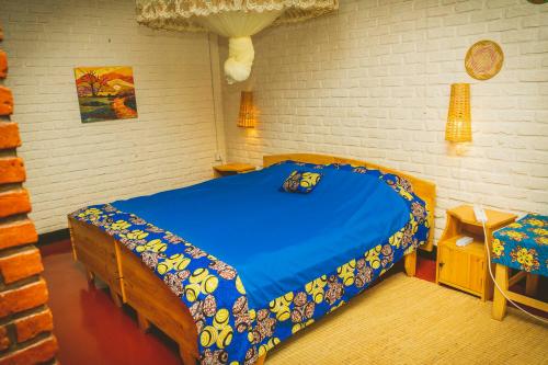 um quarto com uma cama azul num quarto em Room in Guest room - Isange Paradise Resort em Ruhengeri