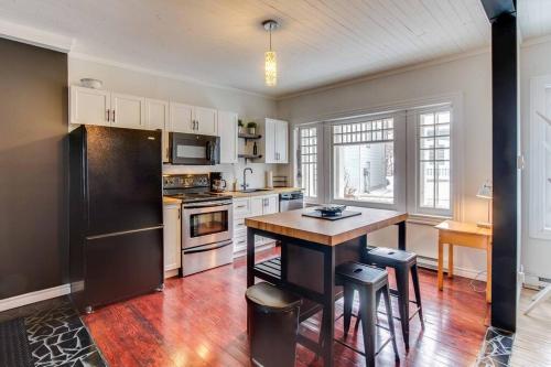 a kitchen with a black refrigerator and a table at La Maison bleue des Artistes in Quebec City